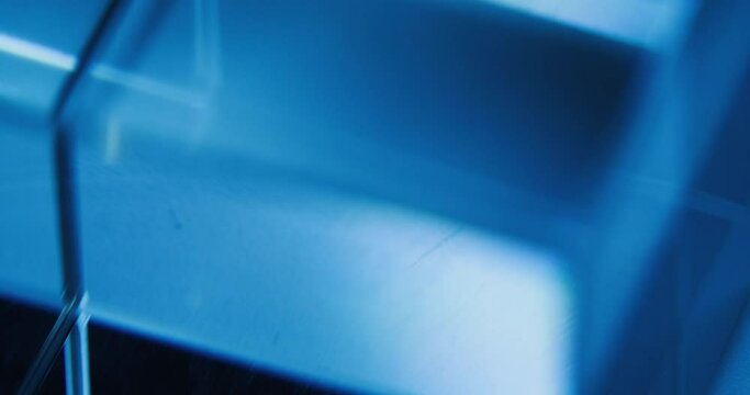 Neon light motion. Geometric abstract background. Glass cube rotation. Defocused blue white color flicker glow empty space for logo. Seamless loop. Shot on RED Cinema camera.