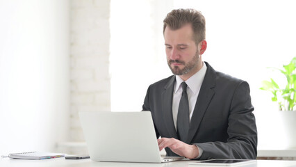 Young Businessman Working on Laptop in Office