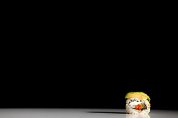 sushi and rolls with different fillings on a black background
