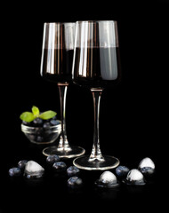 Wine from fresh berries isolated on a black background. The concept of making natural wine. Close-up. Selective focus.