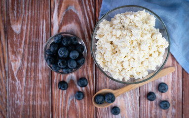 Homemade cottage cheese and fresh berries and on the wooden background. Healthy food concept. Close-up. Copy space. Selective focus.