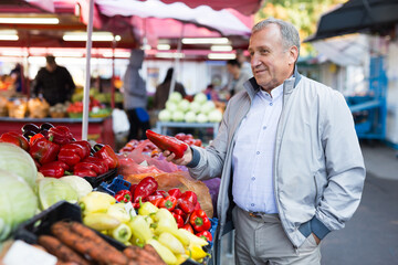 Middle aged man buying peppers