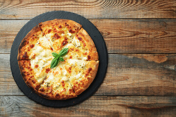 A slice of hot Italian pizza with stretching cheese. Pizza four cheeses with basil.