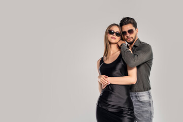 Fashion photo of handsome young couple posing in sunglasses. Studio shot. Personal accessories