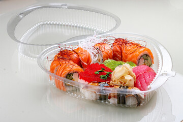 Set of different sushi and rolls in a plastic heart-shaped package. Isolated on a white background