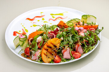 Fresh salad with ham and arugula, with grilled persimmon.