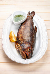 Grilled mackerel with butter and herbs. On a light background.