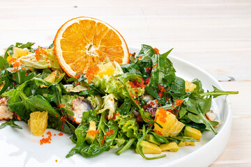 Juicy salad with arugula , orange and avocado. On a light background.