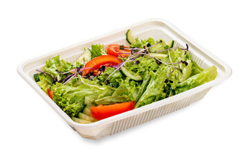 Salad with fresh vegetables and microgreens. In a plastic container. Food to go. On a light background.