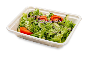 Salad with fresh vegetables and microgreens. In a plastic container. Food to go. On a light background.