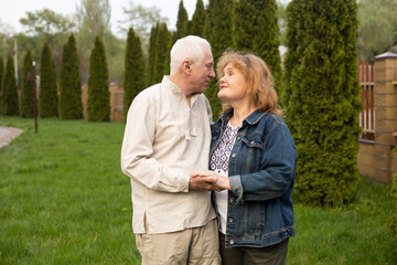 Fototapeta premium mature couple looking on each other outside in autumn or summer nature in park