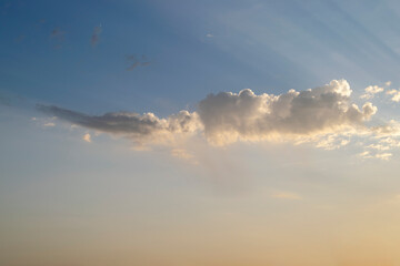 Obraz premium Dramatic blue sky and warm light clouds at sunrise time.