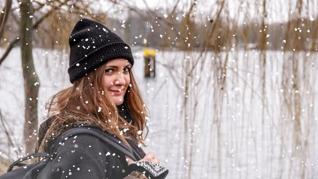 Cinemagraph of young woman outdoors at a lake on snowy day

