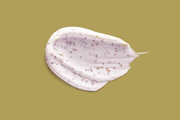 Scrub with cofee or apricot pits, seeds, salt care cosmetics khaki green ochre background isolated