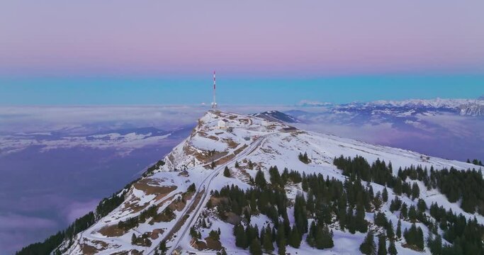 Telecommunications tower on top of Mount Rigi (Rigi Kulm) with amazing snow and fog covered Swiss alps mountain peaks and Lake Lucerne underneath in winter scenery landscape. Aerial drone. Switzerland