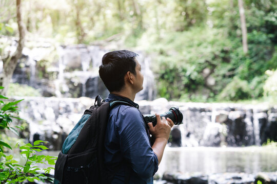 Professional photographers capture the beauty of nature with photographic equipment at a tropical waterfall.Concept of Photography and Travel