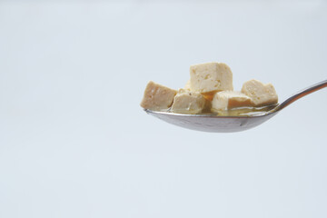 cheese cube on a spoon close up 