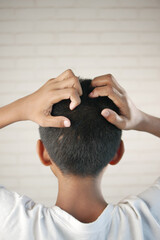 teenage boy Scratching Head Against black background .