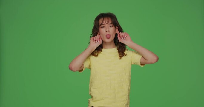 Funny young girl make crazy monkey faces, having fun grimacing cheering, amusing, fooling on chromakey green background