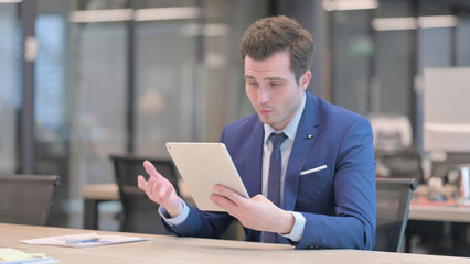 Businessman making Video Call on Tablet in Office