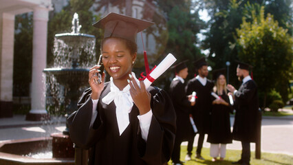 Black lady very beautiful in the graduation day take the phone and call someone she speaks and...