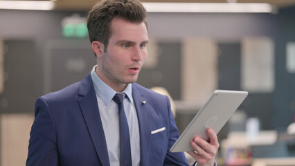 Fototapeta na wymiar Portrait of Businessman having Loss on Tablet in Office