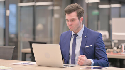 Businessman Reacting to Loss While using Laptop