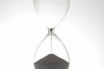Hourglass on a light background. Time is money. Business solutions in time.