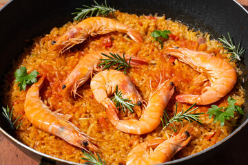 Paella is a traditional spanish food. Paella with seafood in a pan with shrimp. Cooking paella on the street, close-up, top view. Mediterranean seafood dish