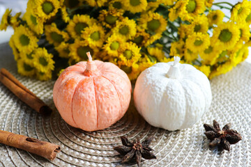 Autumn composition with natural soy wax candles in the form of a pumpkin 