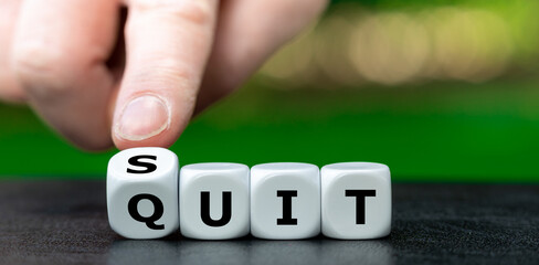 Hand turns dice and changes the word quit to suit.