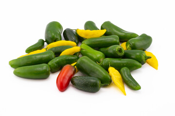 Scattering of green jalapeno peppers and yellow lemon drops pepper isolated on white background.
