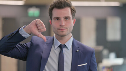 Portrait of Businessman showing Thumbs Down Gesture