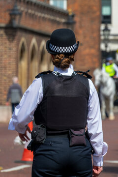 Female London bobby. English policewoman from behind in a street of London UK