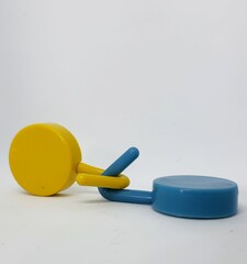 Two round blue and yellow clothes hook hangers that go hand in hand.