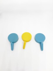 Isolated white photo of three round coat hangers with blue and yellow colors.