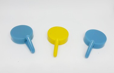 Isolated white photo of three round coat hangers with blue and yellow colors.