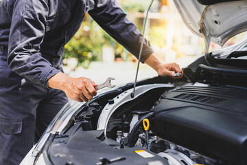 Close-up hands of auto mechanic are using the wrench to repair and maintenance auto engine is problems  Concepts of car care check and fixed and services insurance.