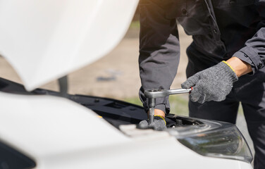 Close-up hands of auto mechanic are using the wrench to repair and maintenance auto engine is problems  Concepts of car care check and fixed and services insurance.
