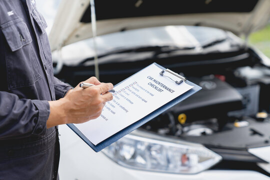 car service and maintenance. Services car engine machine concept, Automobile mechanic repairman checking a car engine with inspecting writing to the clipboard the checklist for repair machine