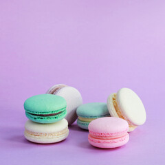 Obraz na płótnie Canvas Macaron or macaroon on lilac background, colorful almond cookies with different fillings