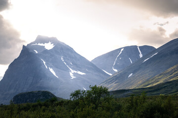 epic mountain vista with dramatic storm light, hiking the Kungsleden trail in swedish lapland