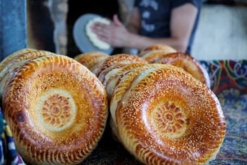 Freshly baked Uzbek flatbreads against the background of a working baker..