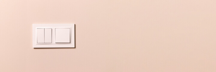 Group of white electrical switches on modern beige wall with copy space banner. Wide panoramic...