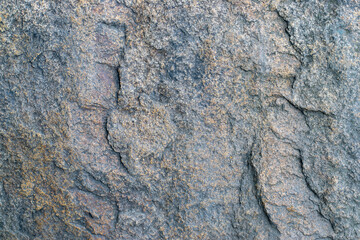 Raw gray granite rock texture background. Fragment of natural stone wall