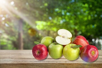 Fresh tasty ripe apples on a wooden table in a garden
