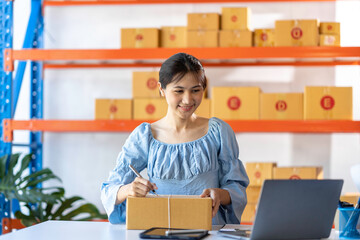 SME entrepreneur Small business entrepreneurs Online selling ideas,Happy Young Asian business owner work on computer and a boxs at home,delivery SME procurement package box deliver to customers