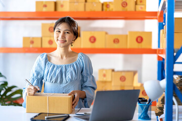 SME entrepreneur Small business entrepreneurs Online selling ideas,Happy Young Asian business owner work on computer and a boxs at home,delivery SME procurement package box deliver to customers