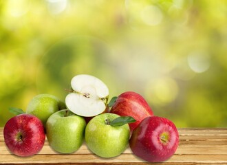 Fresh tasty ripe apples on a wooden table in a garden