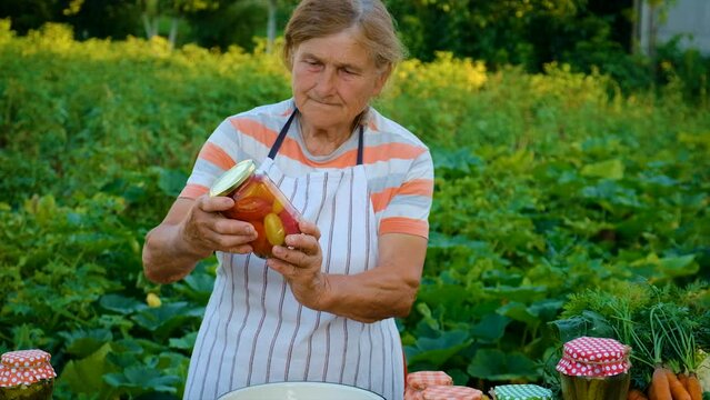 Senior woman makes preservation of vegetables. Selective focus.